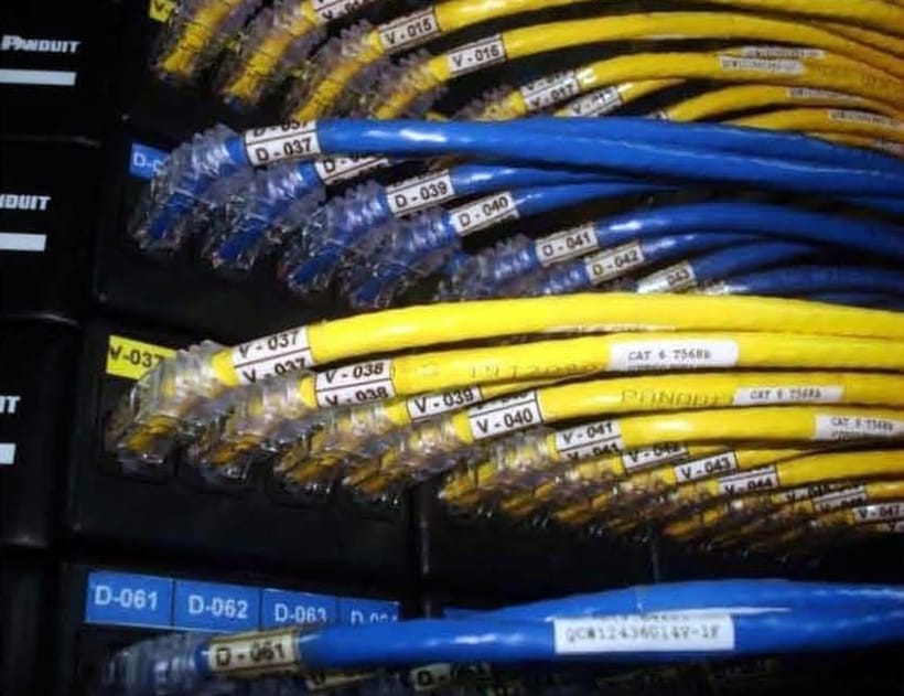 Labelled yellow and blue Cat6 patch cords dressed through a cable manager on a Lantech installation