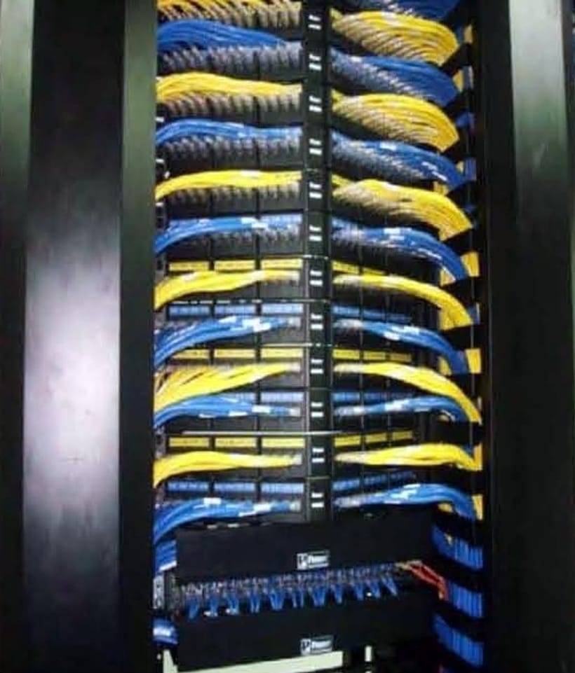 Yellow and blue patch cords dressed across a rack's horizontal managers