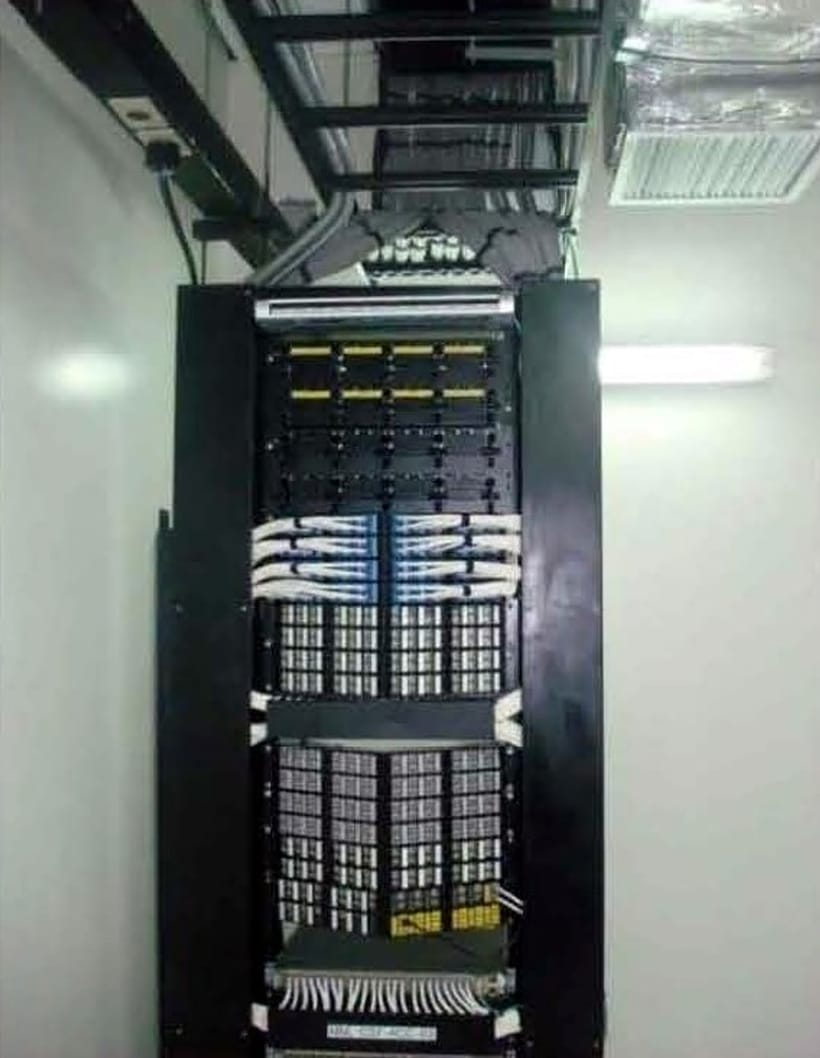 Fully built server rack with patch panels and switches in a finished room